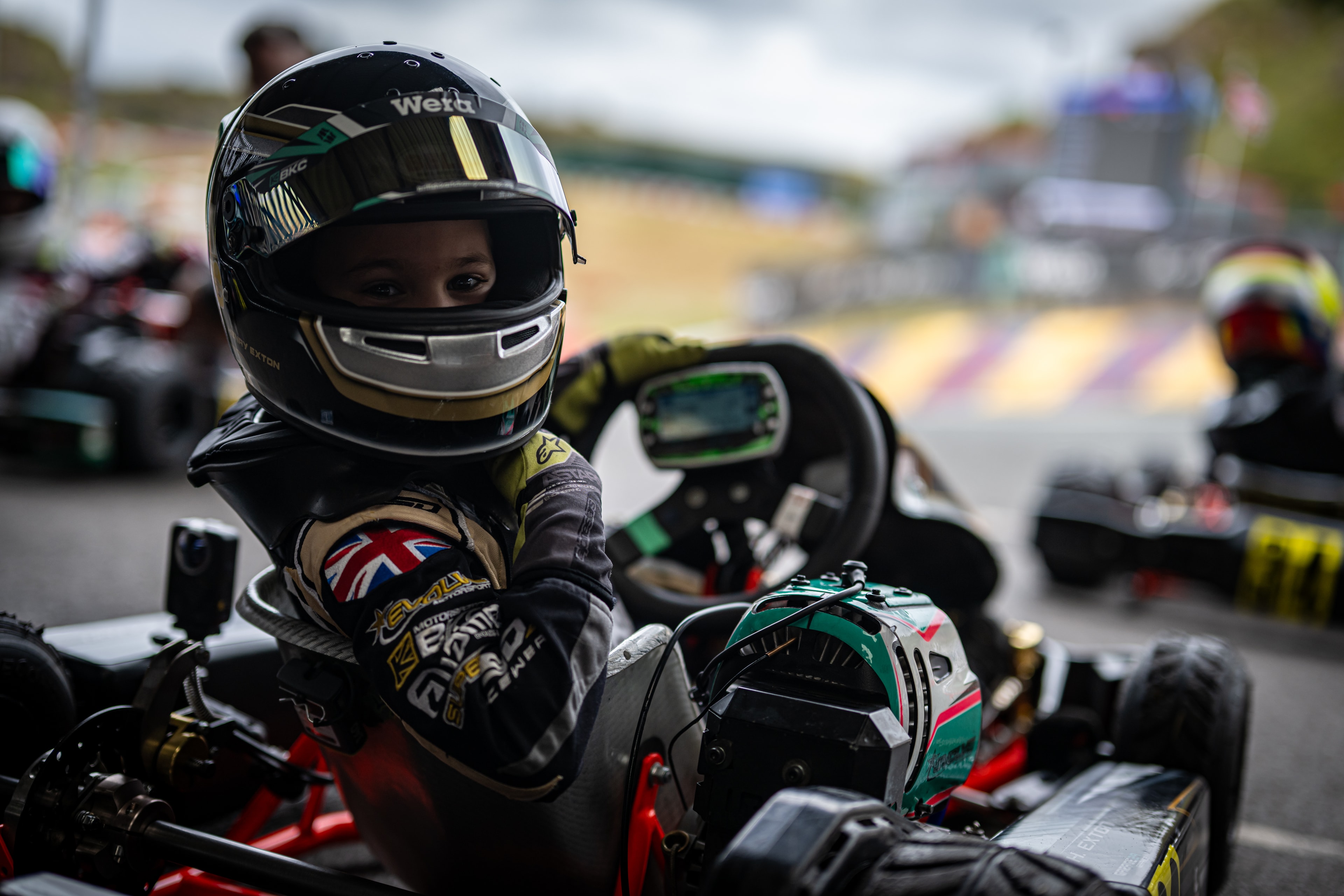 Henry Exton focused in kart cockpit on the grid at Rowrah