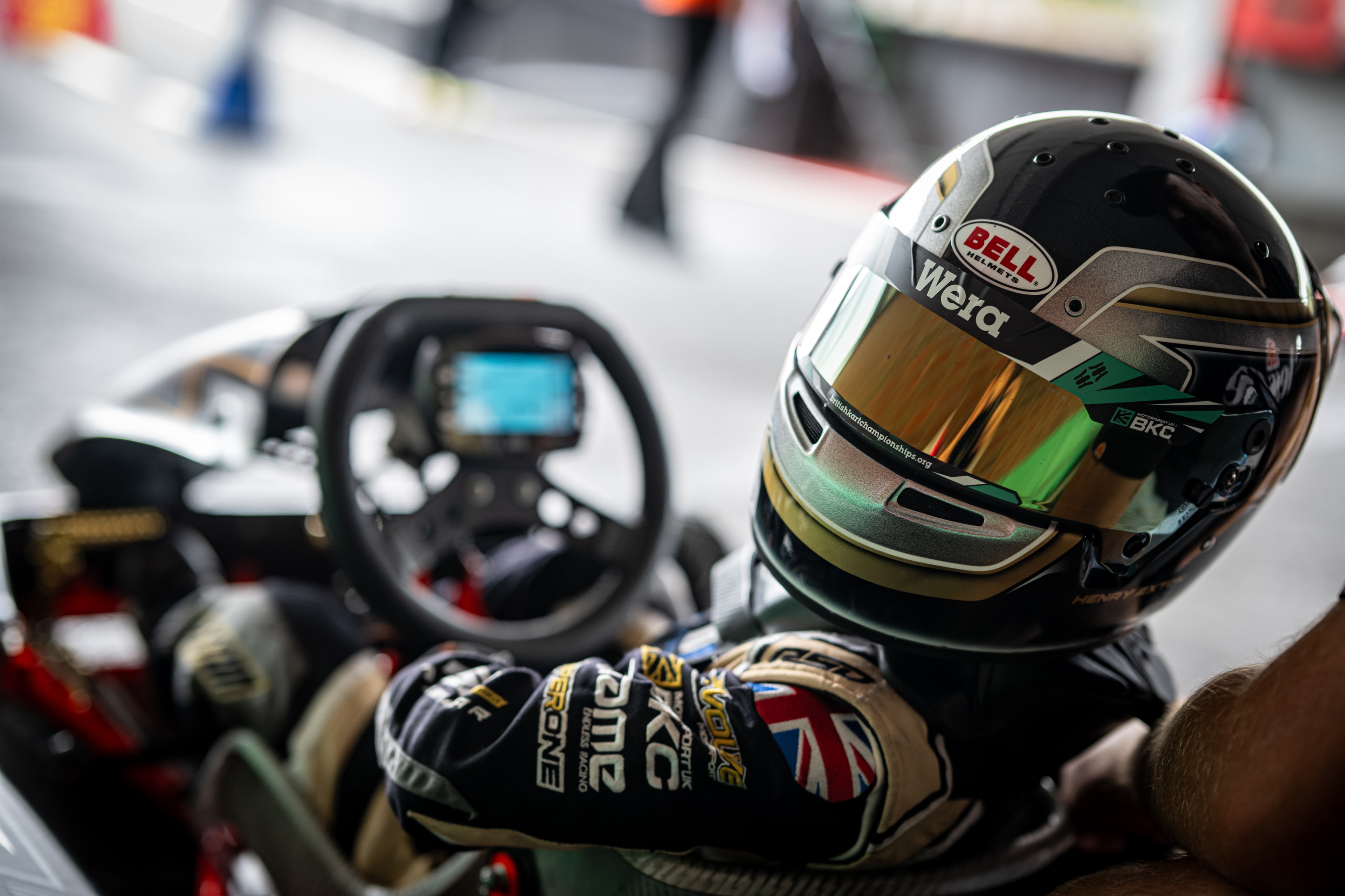 Close-up of Henry Exton Bell Wera helmet in kart cockpit at PFI
